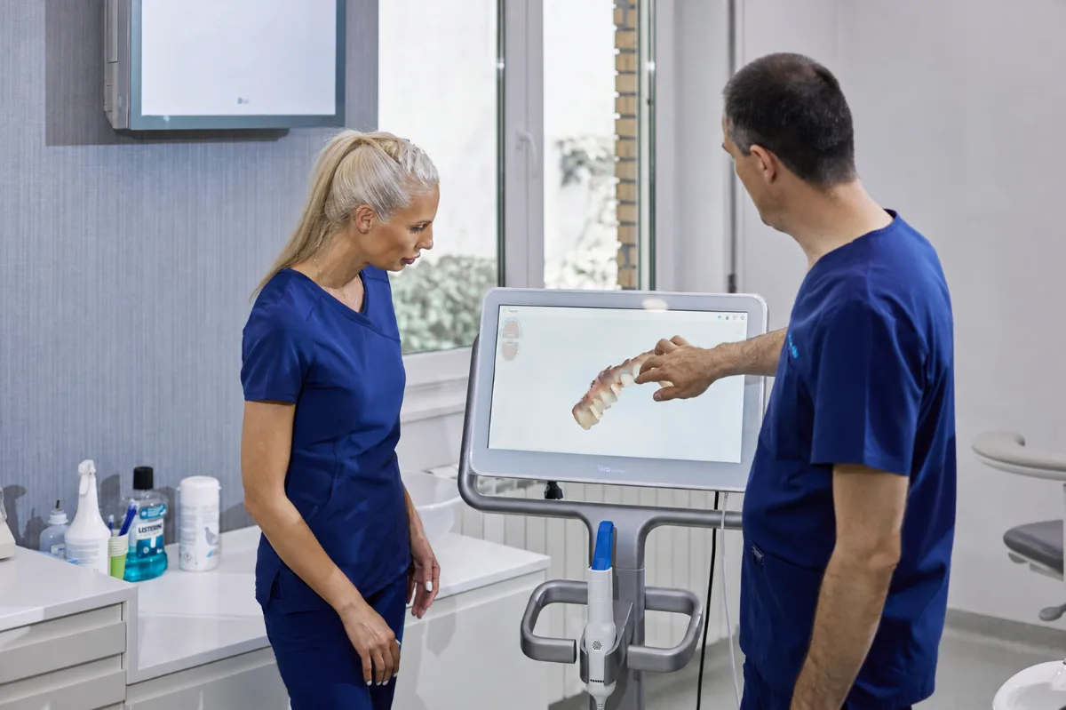 Two dentists at our partner clinic reviewing a patient's 3D intraoral scan on an iTero Element scanner
